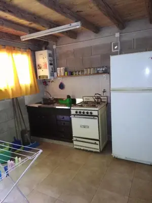 a kitchen with a stove and a white refrigerator at cabañas rio y playa 2 in Atos Pampa