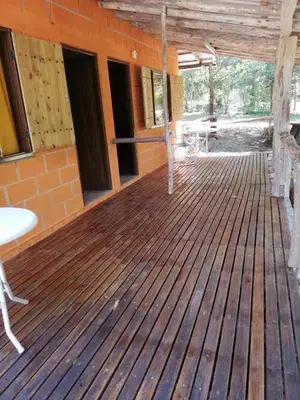 a wooden deck with a table and chairs on it at cabañas rio y playa 2 in Atos Pampa