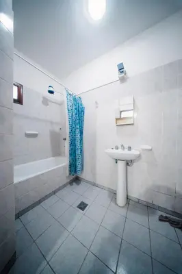a bathroom with a sink and a tub and a toilet at DTOS Villa del Lago in Villa Carlos Paz