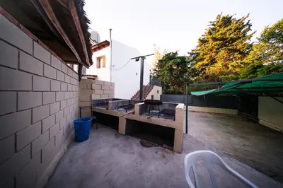 a patio with a table and chairs on a building at DTOS Villa del Lago in Villa Carlos Paz