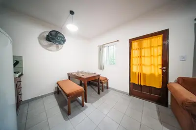 a living room with a table and chairs and a door at DTOS Villa del Lago in Villa Carlos Paz