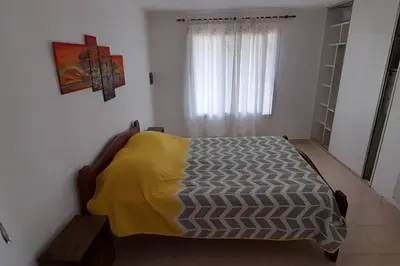 a bedroom with a bed with a yellow blanket on it at Casa con vista a las sierras in Santa María