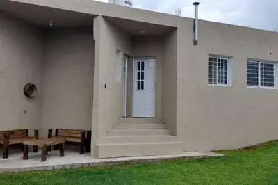 a building with a white door and a bench at Casa con vista a las sierras in Santa María