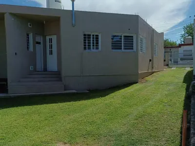 a house with a grass yard in front of it at Casa con vista a las sierras in Santa María