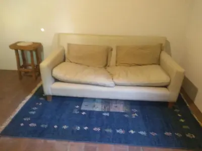 a couch in a living room with a blue rug at Casa alma verde alegría y paz in Luyaba
