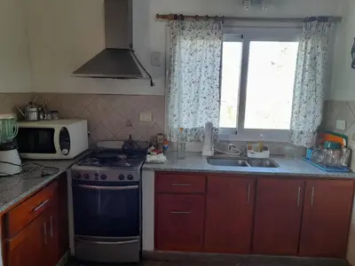 a kitchen with a stove and a microwave and a window at Sol Mayor in Villa Yacanto