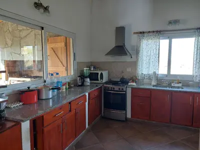 a kitchen with wooden cabinets and a stove top oven at Sol Mayor in Villa Yacanto