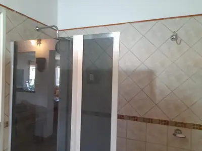 a shower with a glass door in a bathroom at Sol Mayor in Villa Yacanto