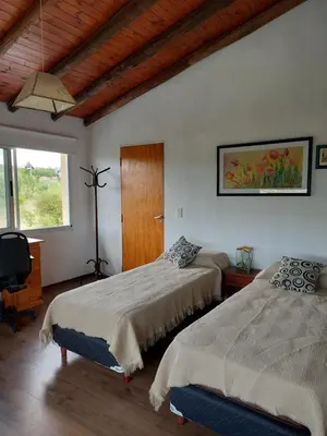 a bedroom with two beds and a television in it at Sol Mayor in Villa Yacanto