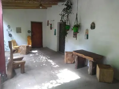 a room with wooden tables and benches in a room at Casa Alma Verde armonia in Luyaba