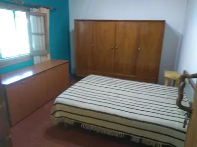a bedroom with a bed and wooden cabinets and a window at Casa Alma Verde armonia in Luyaba