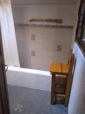 a bathroom with a shower with a table and a tub at Casa Alma Verde armonia in Luyaba