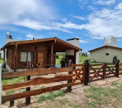 a wooden fence in front of a house at CABAÑA PRIVADA NALÚ in Villa Ciudad Parque