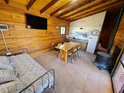 a dining room with a table and a kitchen at CABAÑA PRIVADA NALÚ in Villa Ciudad Parque