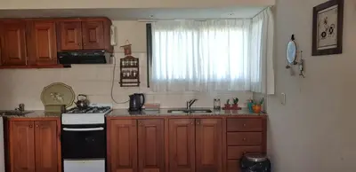 a kitchen with wooden cabinets and a stove and a window at Aldea de Montaña ,La Pichuca in Carpintería