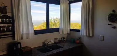 a kitchen with a sink and two windows at Aldea de Montaña ,La Pichuca in Carpintería