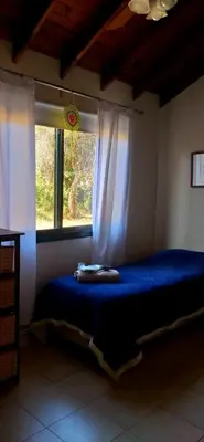 a bedroom with a blue bed with a window at Aldea de Montaña ,La Pichuca in Carpintería