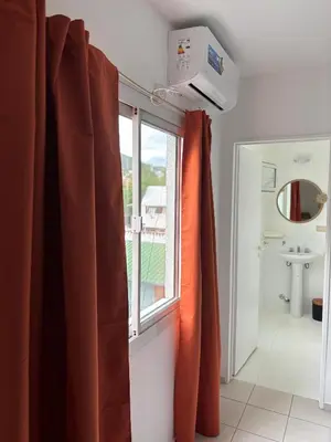 a bathroom with an orange curtain and a window at 255 TUPUNGATO con COCHERA in Villa Carlos Paz
