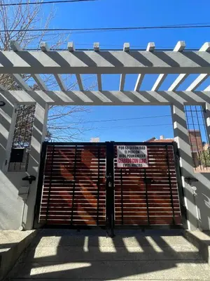 a large wooden garage door with a sign on it at 255 TUPUNGATO con COCHERA in Villa Carlos Paz