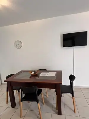 a dining room table with chairs and a clock on the wall at 255 TUPUNGATO con COCHERA in Villa Carlos Paz