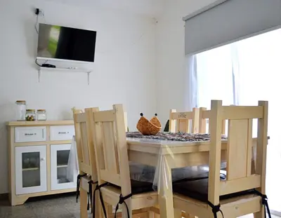 a dining room with a table with chairs and a tv at Cholito 2 in Alta Gracia