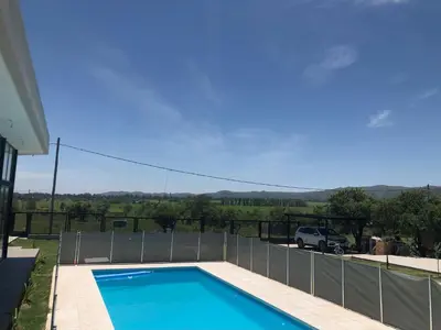 a swimming pool in the backyard of a house at Olivos del Solar in Villa General Belgrano