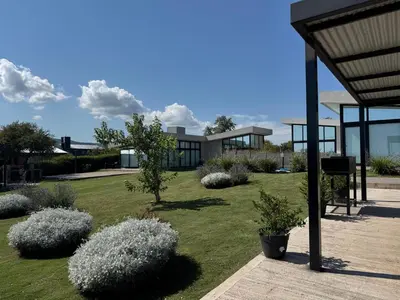 a building with a yard with bushes and trees at Olivos del Solar in Villa General Belgrano