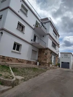 a large white building with a lot of windows at Balcones del Cerro Departamento con cochera in Villa Carlos Paz