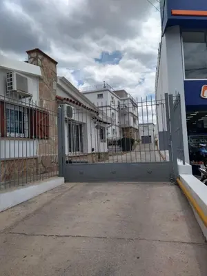 a fence in front of a building with buildings at Balcones del Cerro Departamento con cochera in Villa Carlos Paz