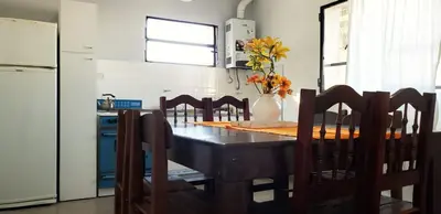 a kitchen with a table with chairs and a vase of flowers at Balcones del Cerro Departamento con cochera in Villa Carlos Paz
