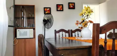a dining room table with a vase of flowers on it at Balcones del Cerro Departamento con cochera in Villa Carlos Paz