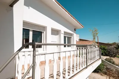 a balcony of a white house with a white railing at American Hoteles in Villa Carlos Paz