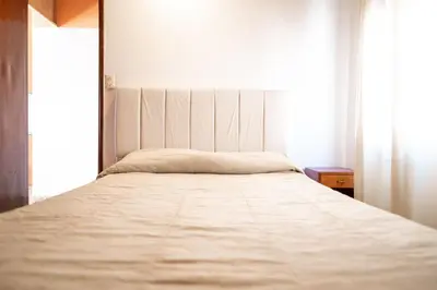 a large bed in a room with a large window at American Hoteles in Villa Carlos Paz