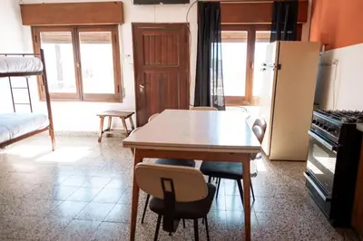 a kitchen with a table and chairs and a refrigerator at American Hoteles in Villa Carlos Paz