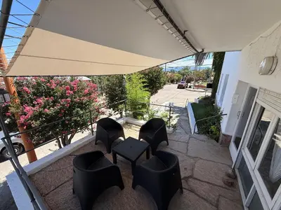 a patio with chairs and a table and an umbrella at American Hoteles in Villa Carlos Paz