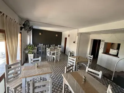 a restaurant with tables and chairs and a chalkboard at American Hoteles in Villa Carlos Paz