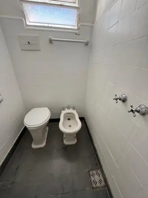 a small bathroom with a toilet and a bidet at American Hoteles in Villa Carlos Paz