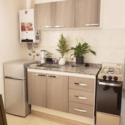 a kitchen with a sink and a stove at Balcones del Cerro Mono ambiente céntrico 2p - camas simples in Villa Carlos Paz