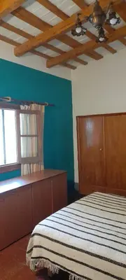a bedroom with a bed and a blue wall at Casa Alma Verde calma in Luyaba