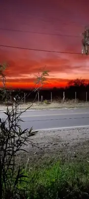 a road with a red sunset in the sky at Casa Alma Verde calma in Luyaba