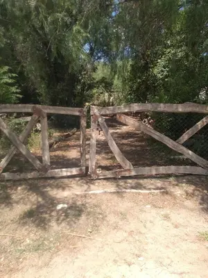 a wooden gate in a field with trees at Casa Alma Verde calma in Luyaba