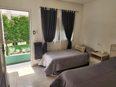 a bedroom with two beds and a large window at Maktub Alta Gracia, Complejo para Turistas in Alta Gracia