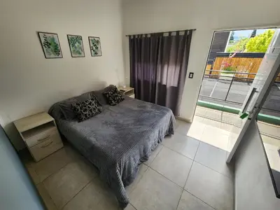 a bedroom with a bed and a large window at Maktub Alta Gracia, Complejo para Turistas in Alta Gracia