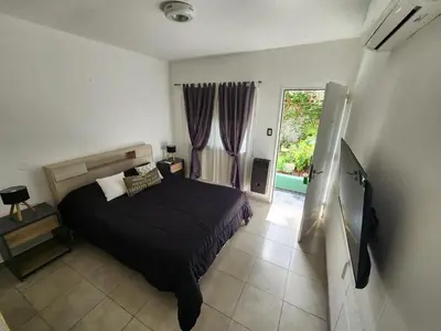 a bedroom with a bed and a large window at Maktub Alta Gracia, Complejo para Turistas in Alta Gracia