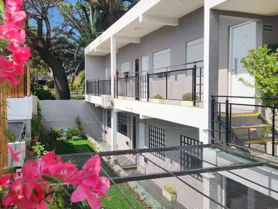 a balcony of a building with pink flowers at Maktub Alta Gracia, Complejo para Turistas in Alta Gracia