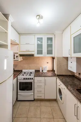 a kitchen with white cabinets and a stove at Excelente depto 2 habitaciones en Nueva cordoba By Lofty in Cordoba