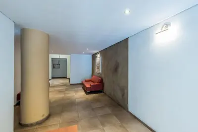 a hallway with a red couch and a column at Excelente depto 2 habitaciones en Nueva cordoba By Lofty in Cordoba