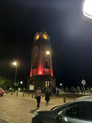 a clock tower at night with people walking in front of it at El Paraiso - Jose de La Quintana in José de la Quintana