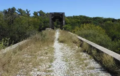a dirt road with a bridge in the background at El Paraiso - Jose de La Quintana in José de la Quintana