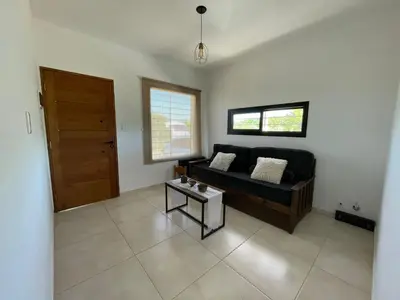 a living room with a black couch and a table at El Paraiso - Jose de La Quintana in José de la Quintana